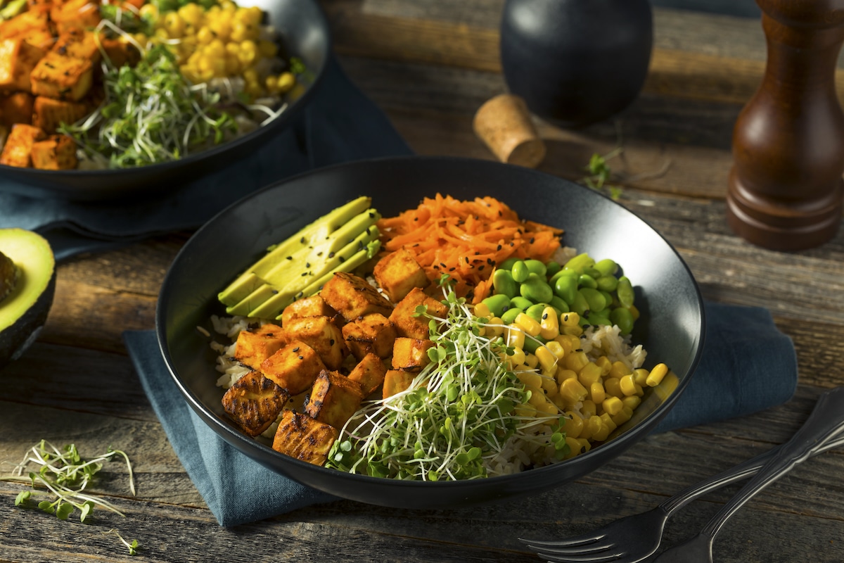Vegan Buddha bowls with tofu, sweet potatoes, sprouts and other vegetables on rice