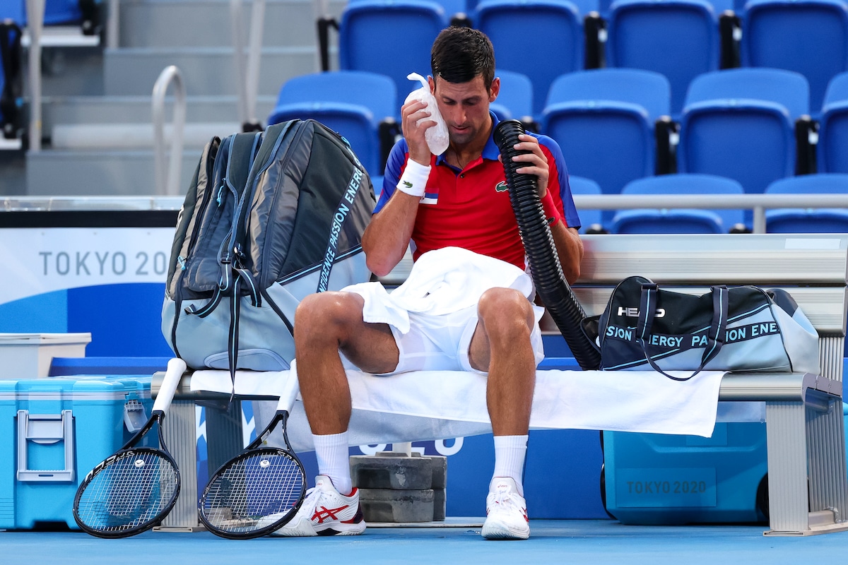 Serbian tennis player Novak Djokovic uses a mobile air conditioner and ice pack to cool down in the extreme heat during the Tokyo 2020 Olympic Games at Ariake Tennis Park in Tokyo, Japan