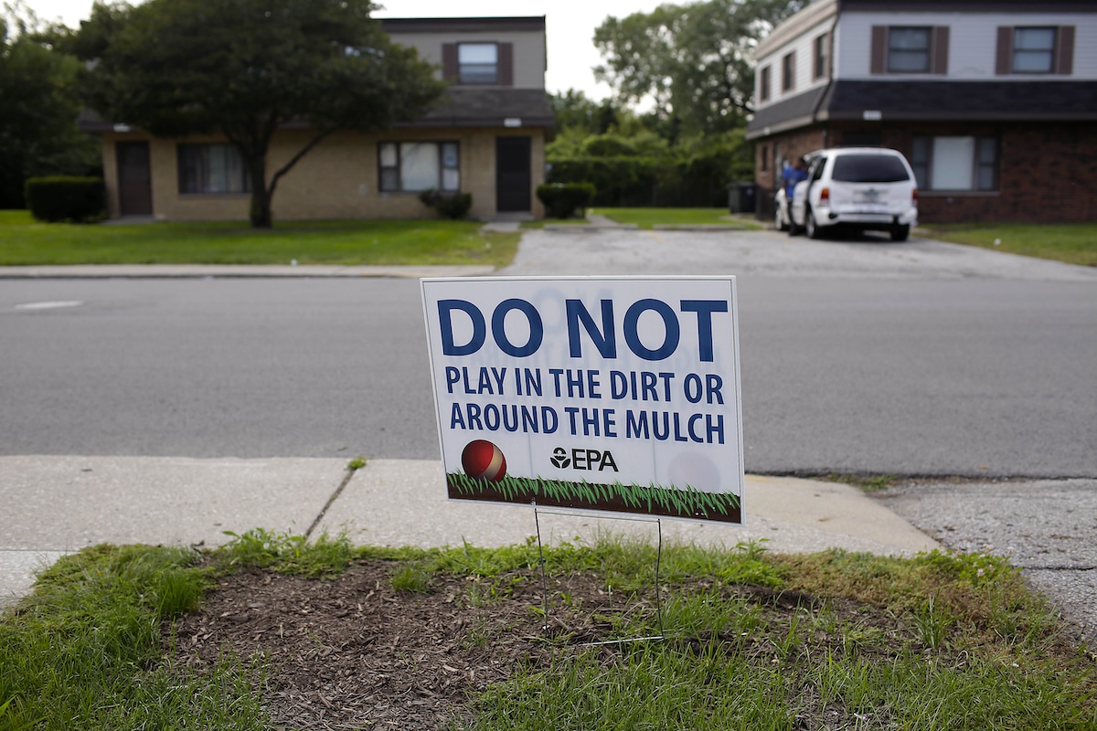 A front yard sign warns residents not to play in the dirt or mulch, which was found to contain high levels of lead and arsenic, at the West Calumet Housing Complex in East Chicago, Indiana