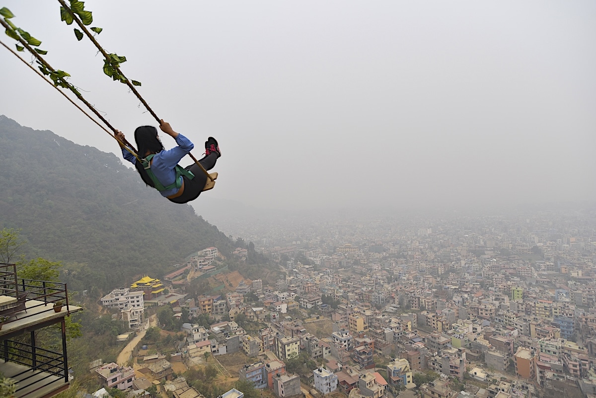 A girl plays on an installed swing on Single Tree Hill at Halchowk, Kathmandu, Nepal on March 29, 2021, as Nepal’s capital was deemed to be the world’s most polluted city by IQAir